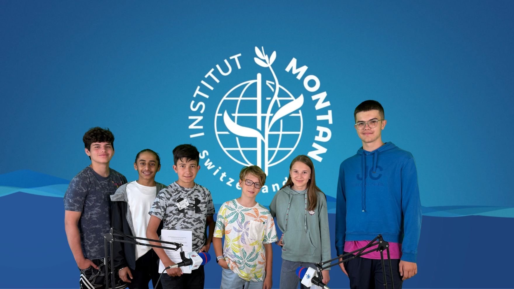 A group of kids in front of a blue backdrop.