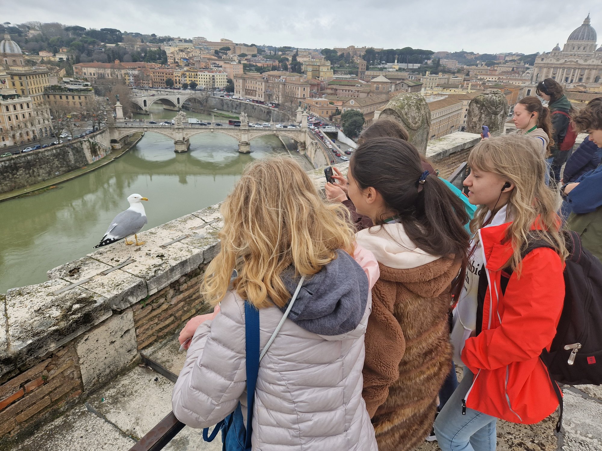 A group of students in a trip, enjoy a city view with a canal.