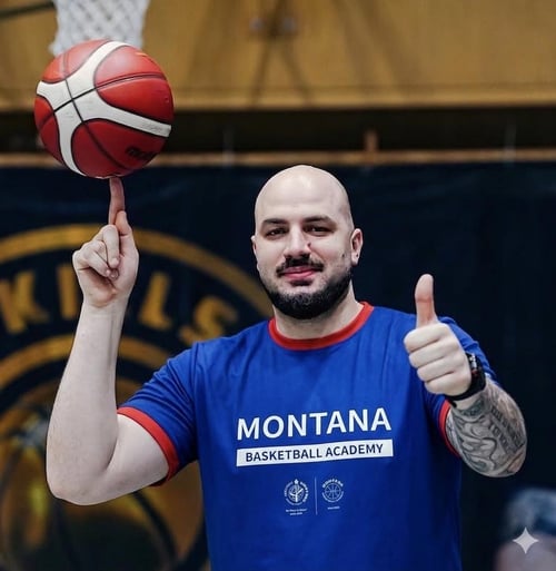 A basketball player holding a basketball on his index finger.