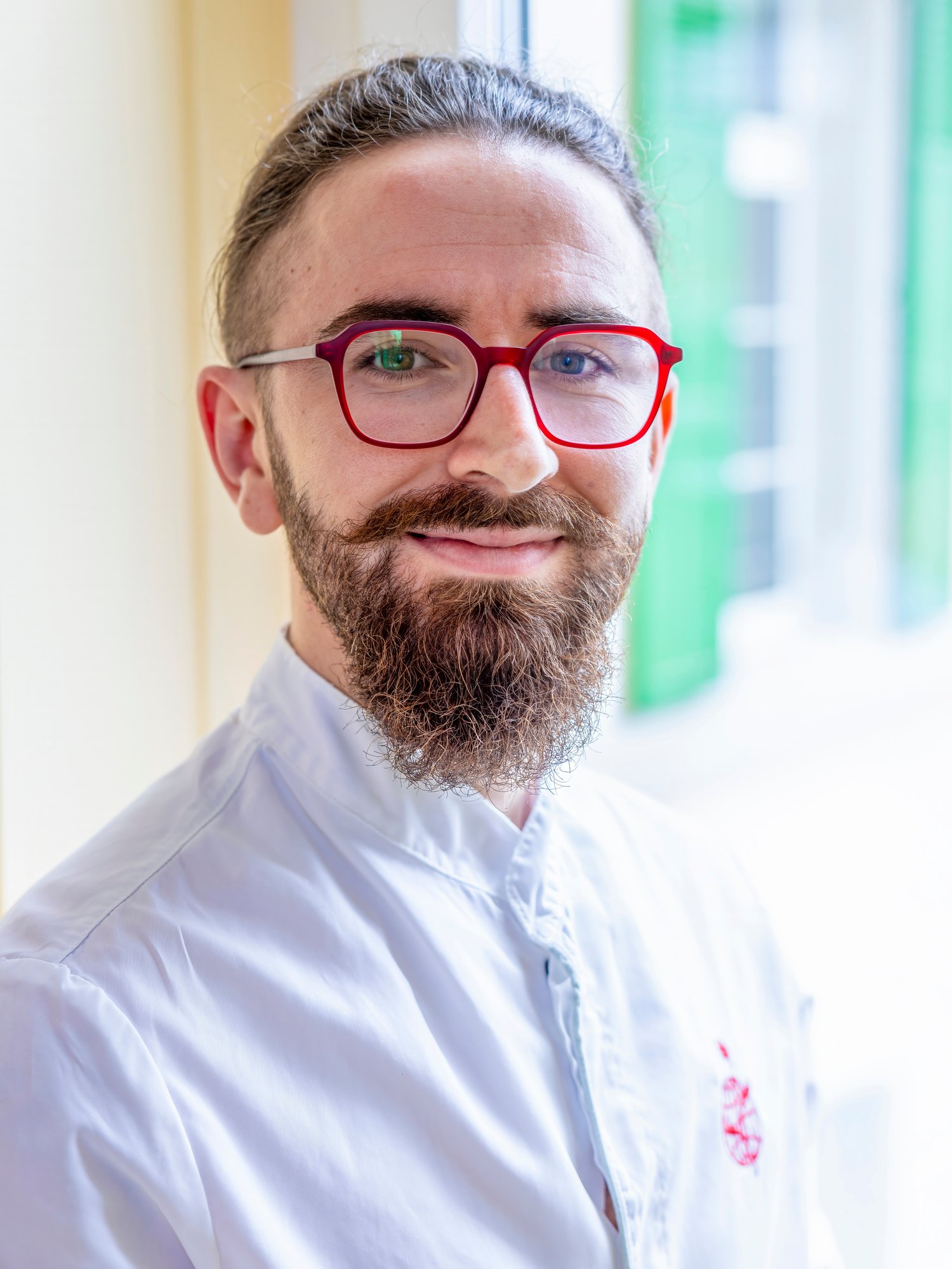 A man in red framed glasses. A man in red framed glasses.
