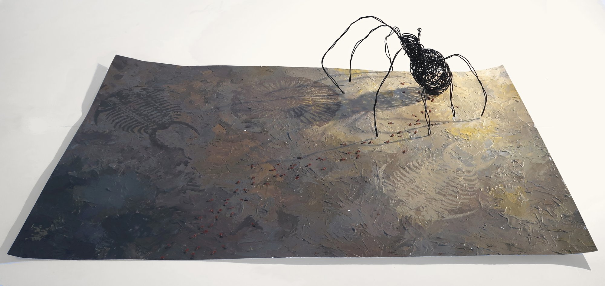 An artwork with a canvas and insect on a corner.