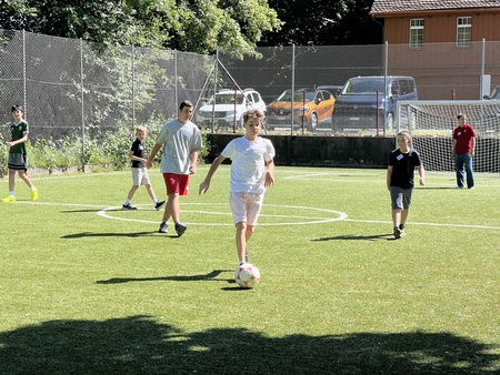 Some kids play football on a field.