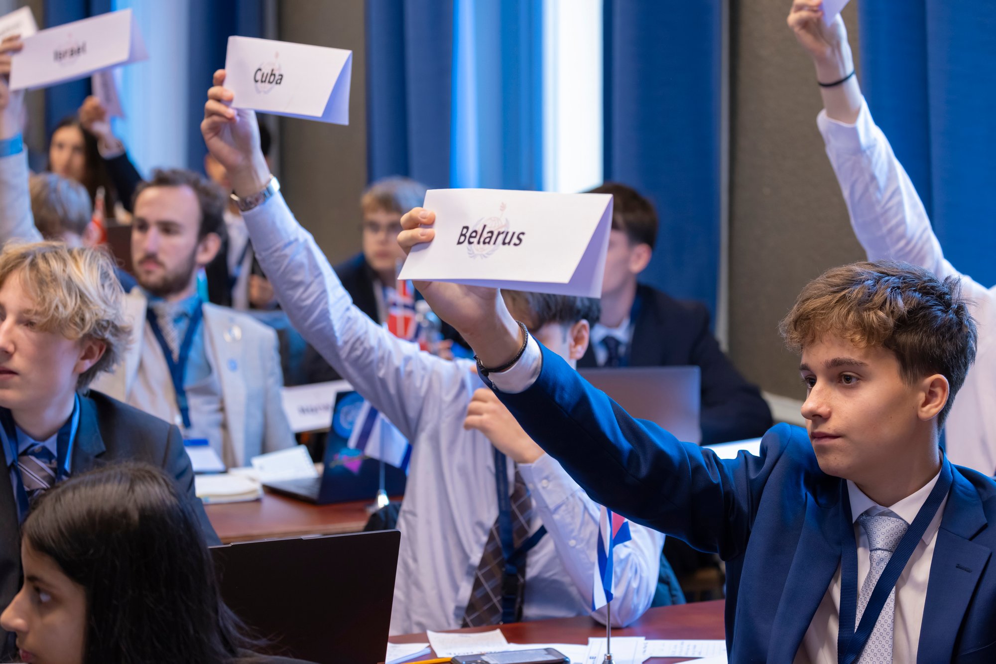 Eine Gruppe von Studenten hebt die Länderzeichen ihrer Delegierten
