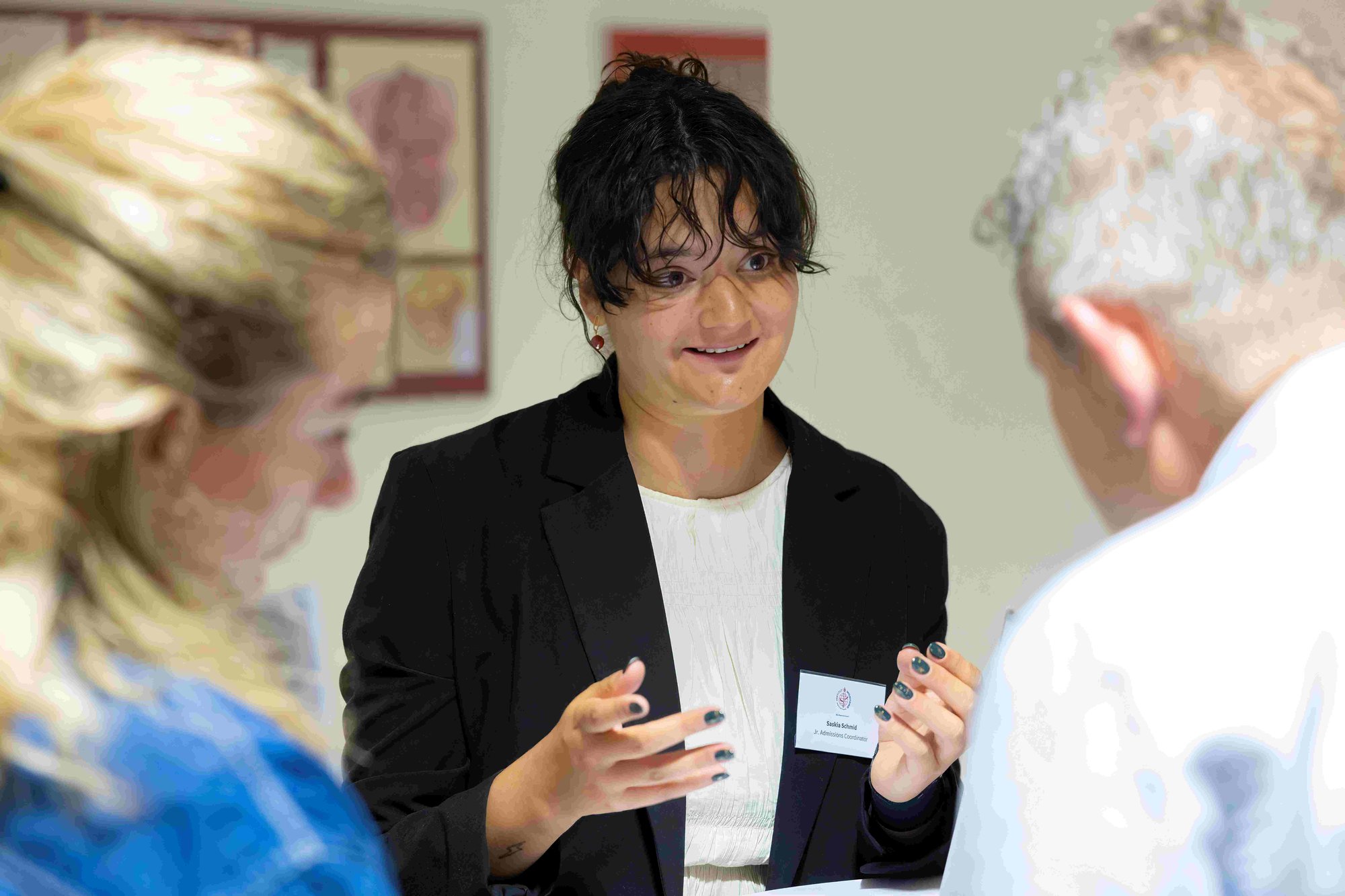 A woman in black blazer talks to parents. A woman in black blazer talks to parents.