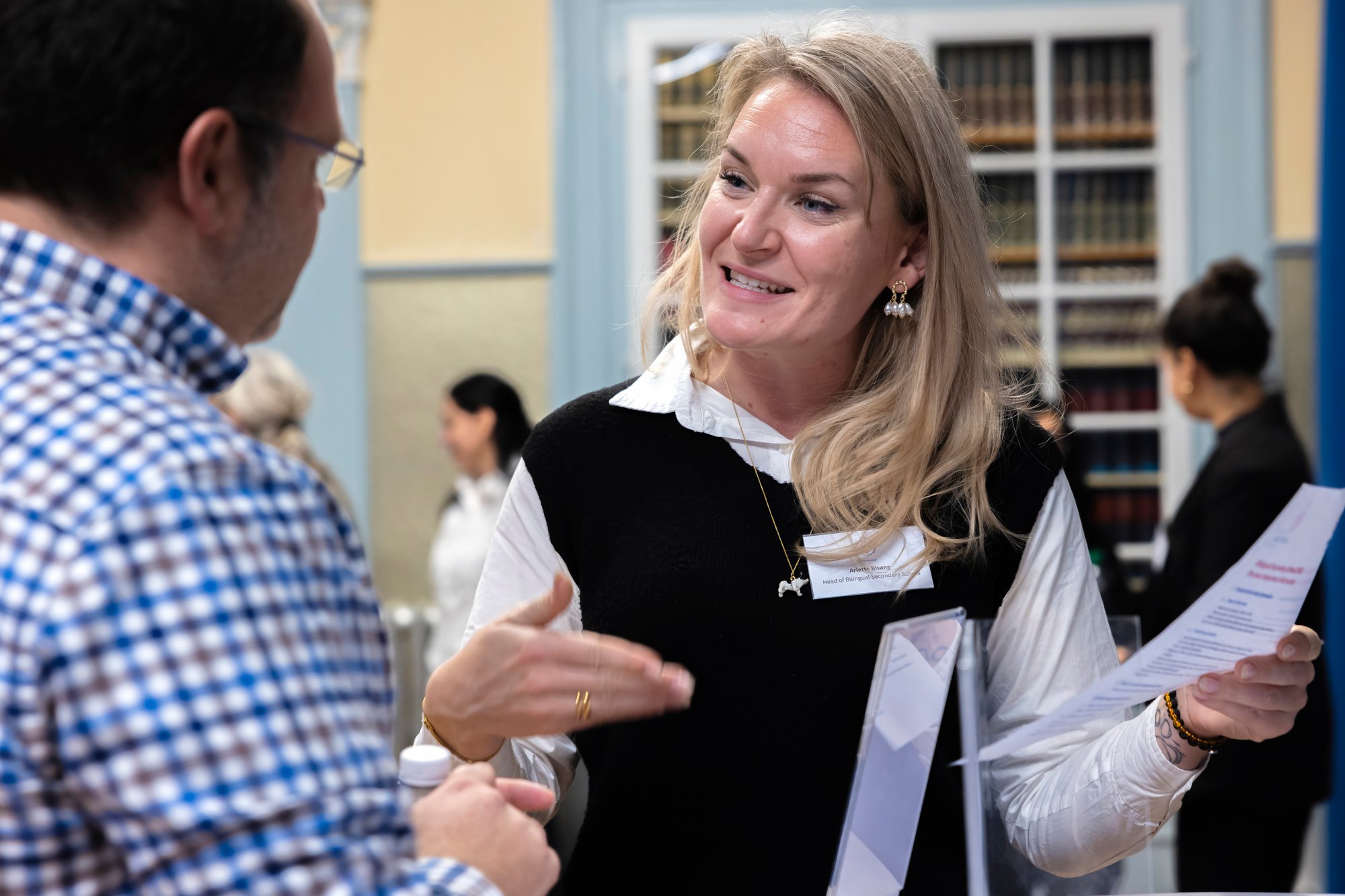 Eine blonde Frau spricht mit einem Mann.