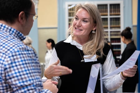 Eine blonde Frau spricht mit einem Mann.