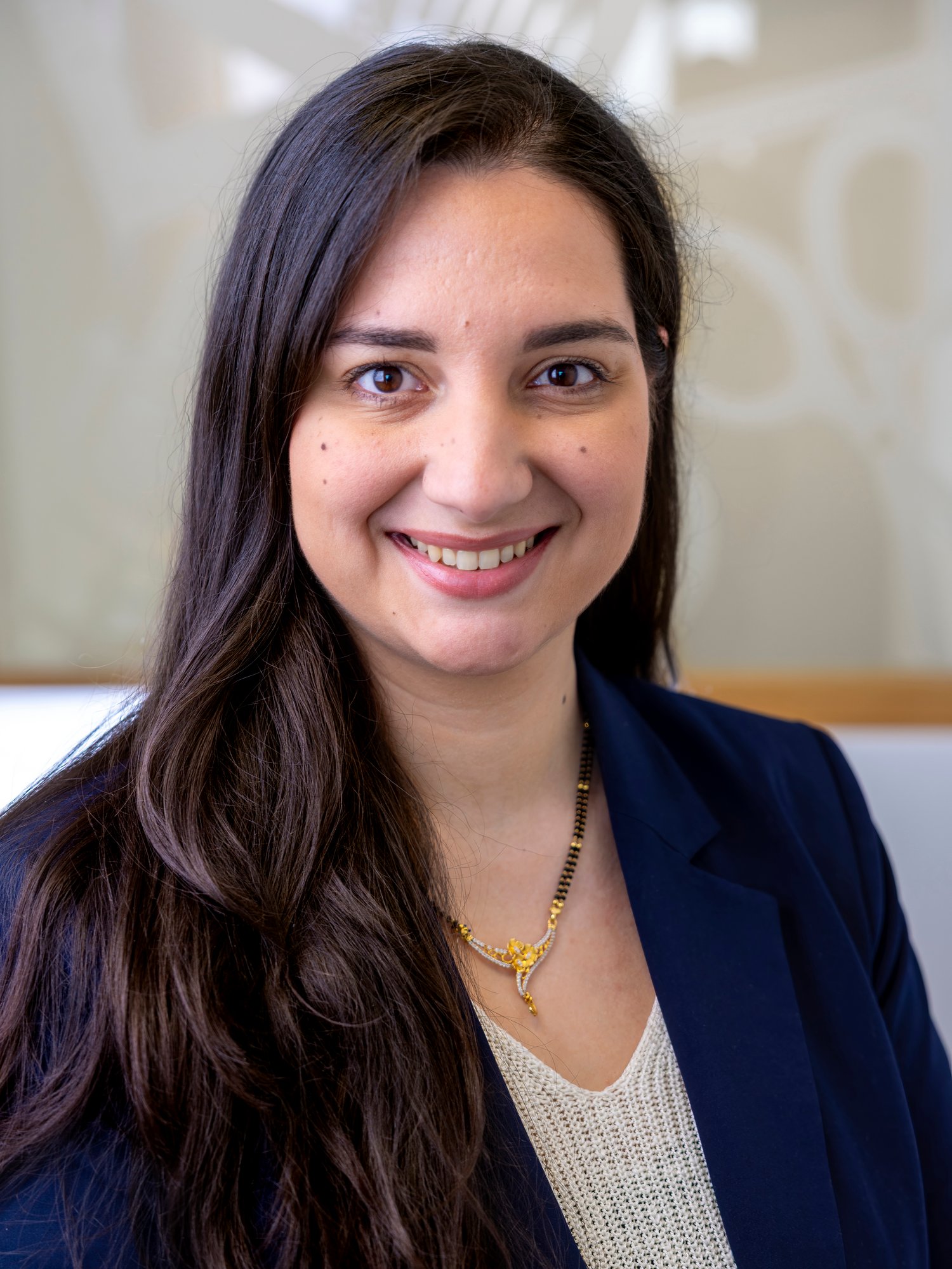 Eine schwarzhaarige Dame in einem schwarzen Blazer.