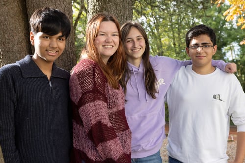 Vier Schüler mit multikulturellem Aussehen posieren vor der Kamera.