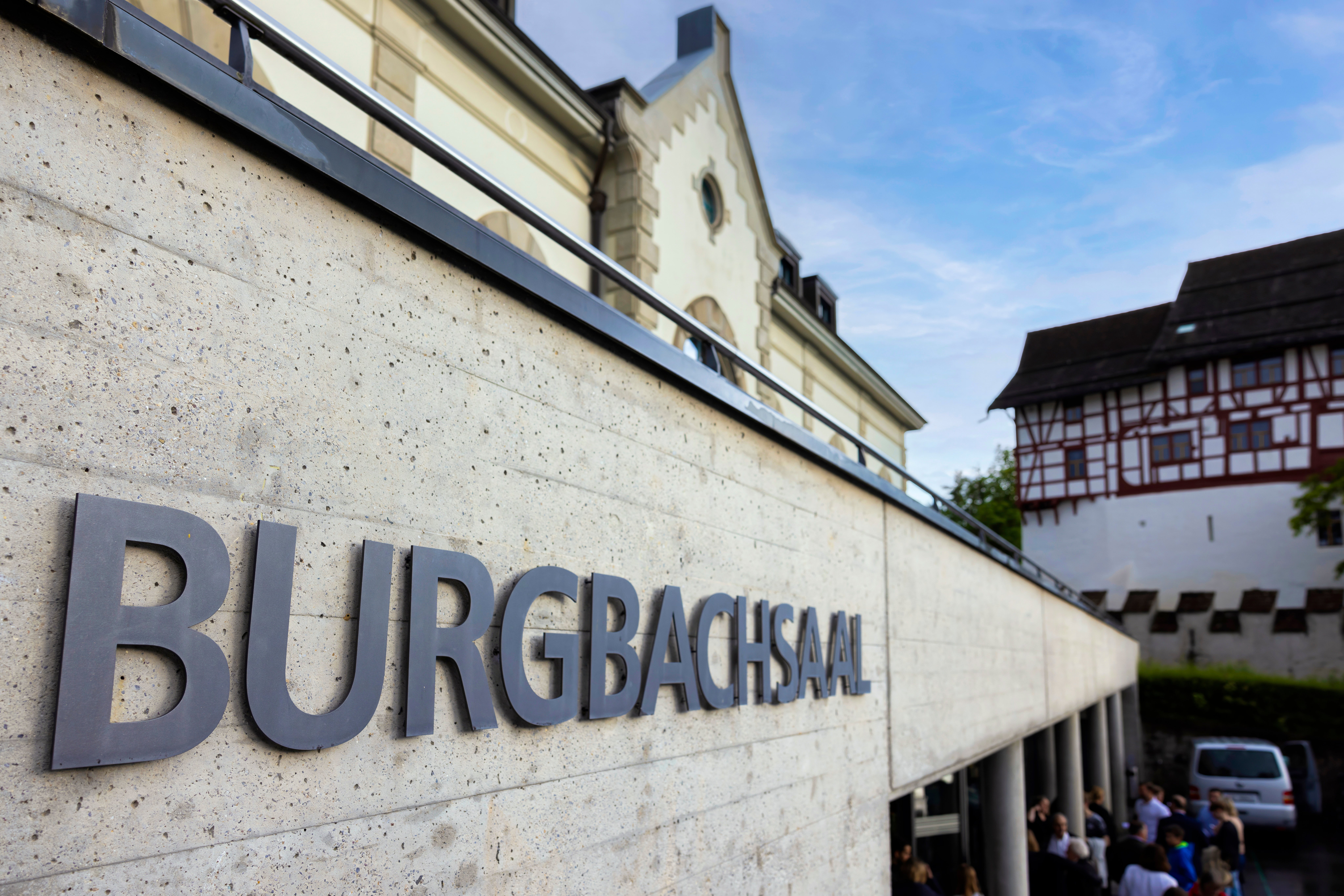 Die Vorderseite eines Gebäudes mit einem großen Schild Burgbachsaal.
