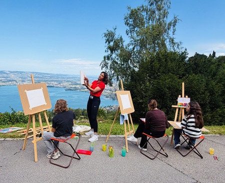 Four people paint outdoor.