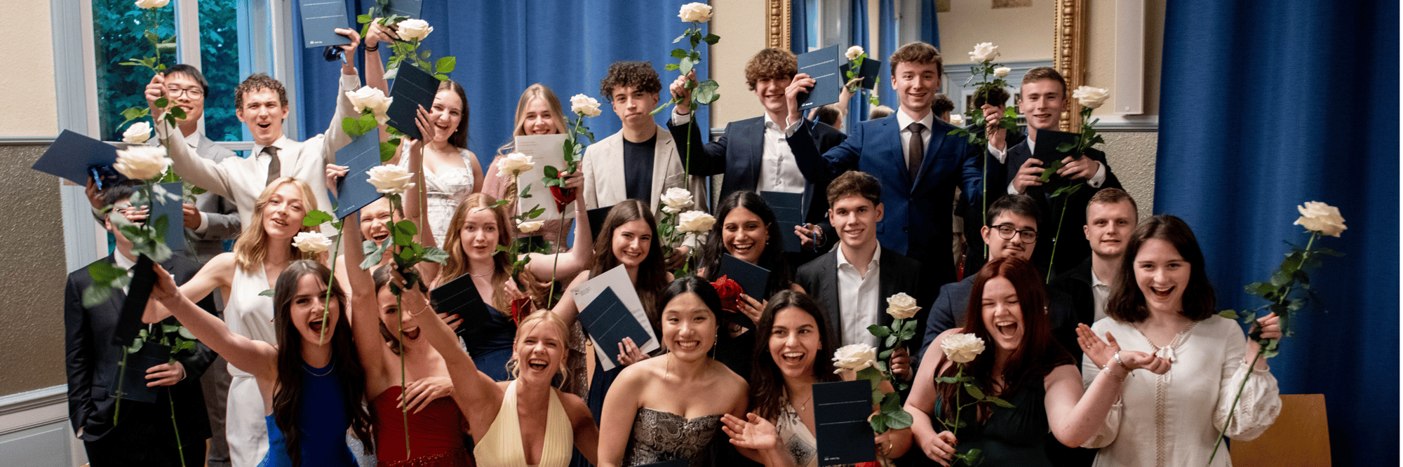ine Gruppe von Studenten posiert an ihrem Abschlusstag mit weißen Rosen in der Hand.